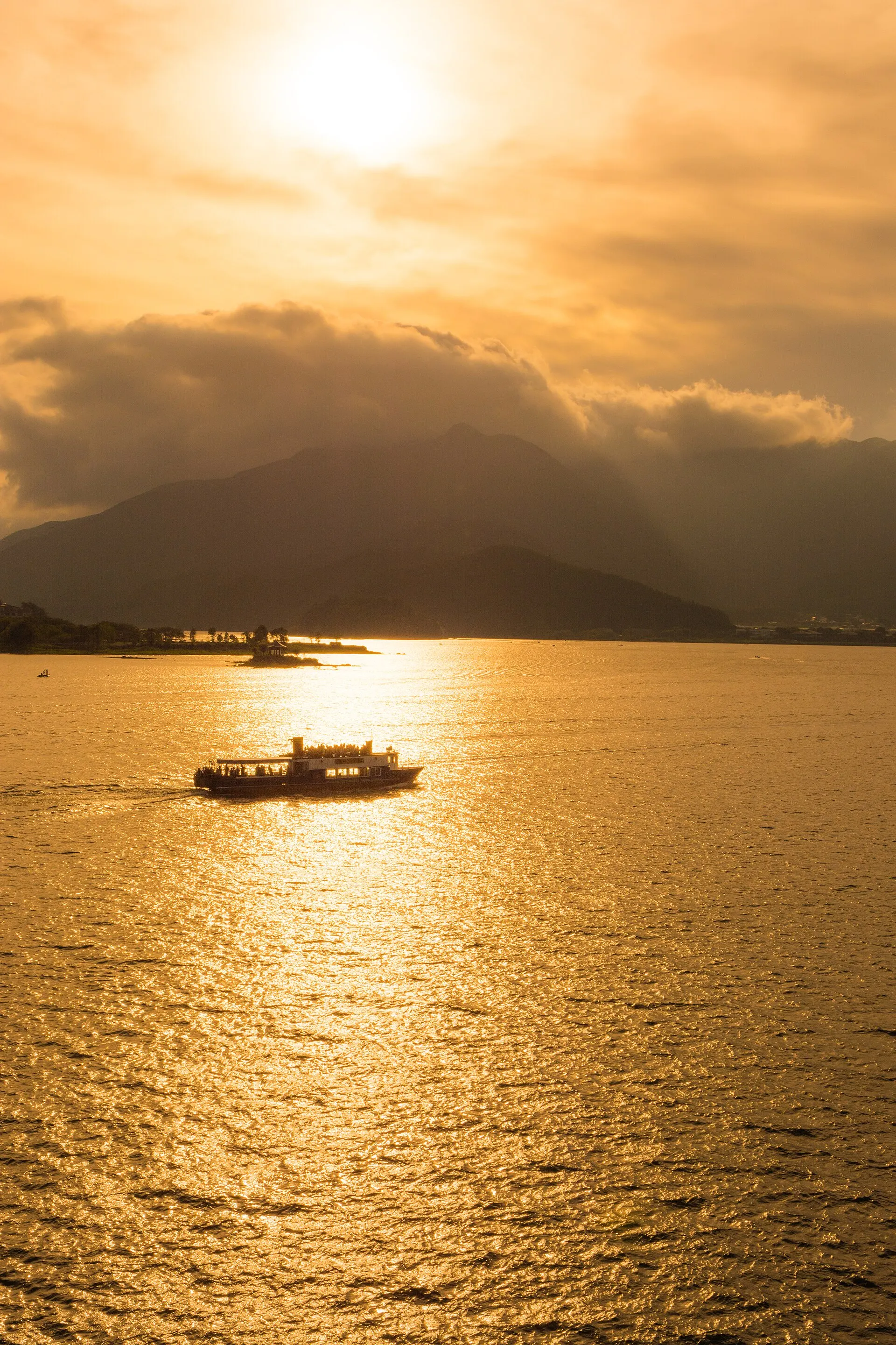 夕日に金色に輝く河口湖と遊覧船