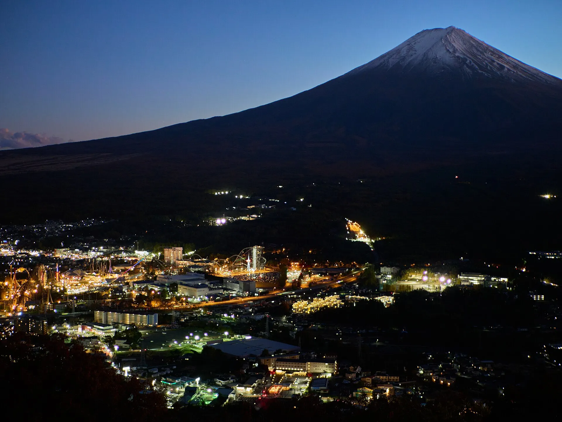 夜明け前の街明かりの向こうに浮かぶ富士山