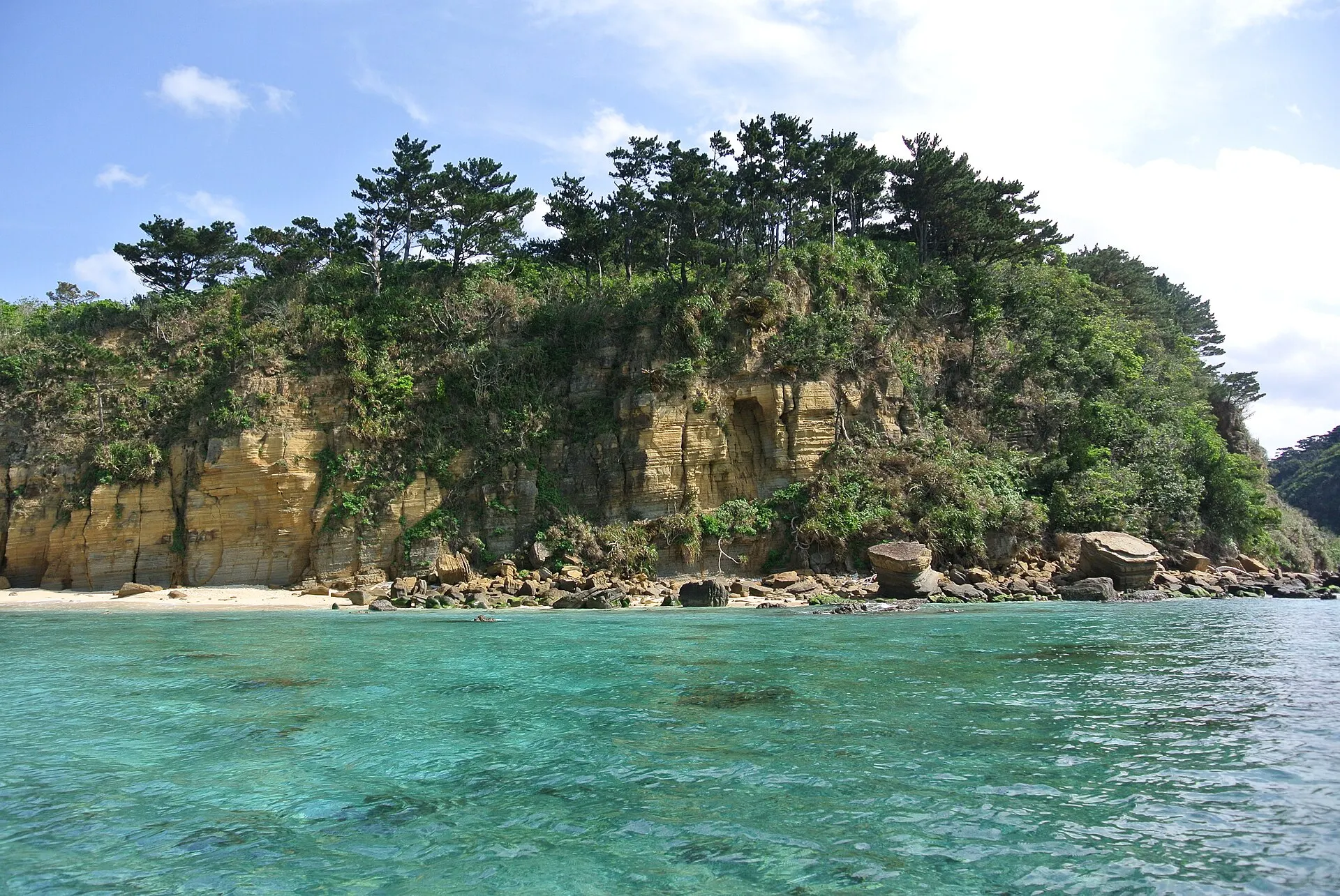 緑の岩山と透明な海の入り江