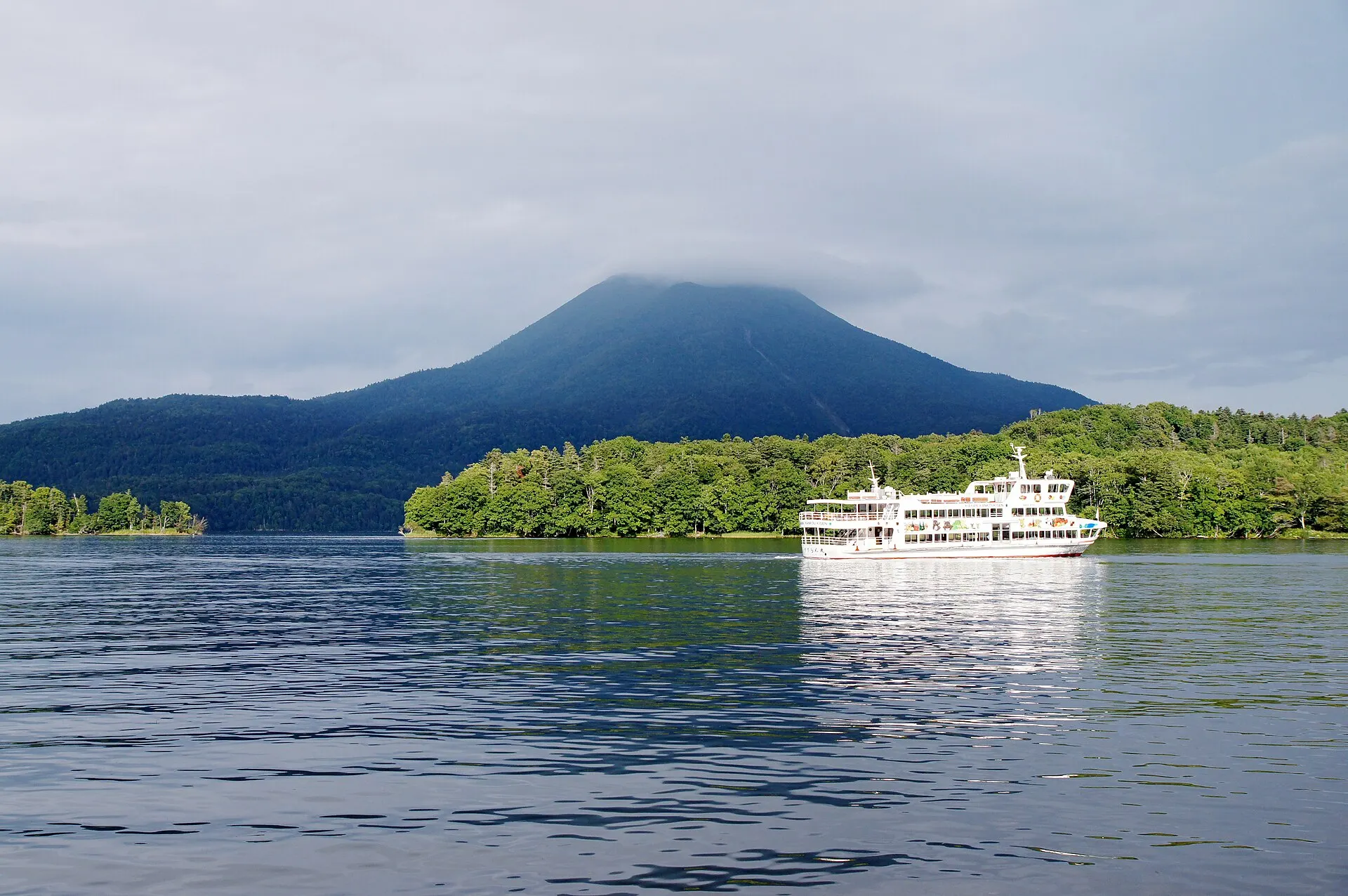 湖に浮かぶ小島と遠くの雄阿寒岳