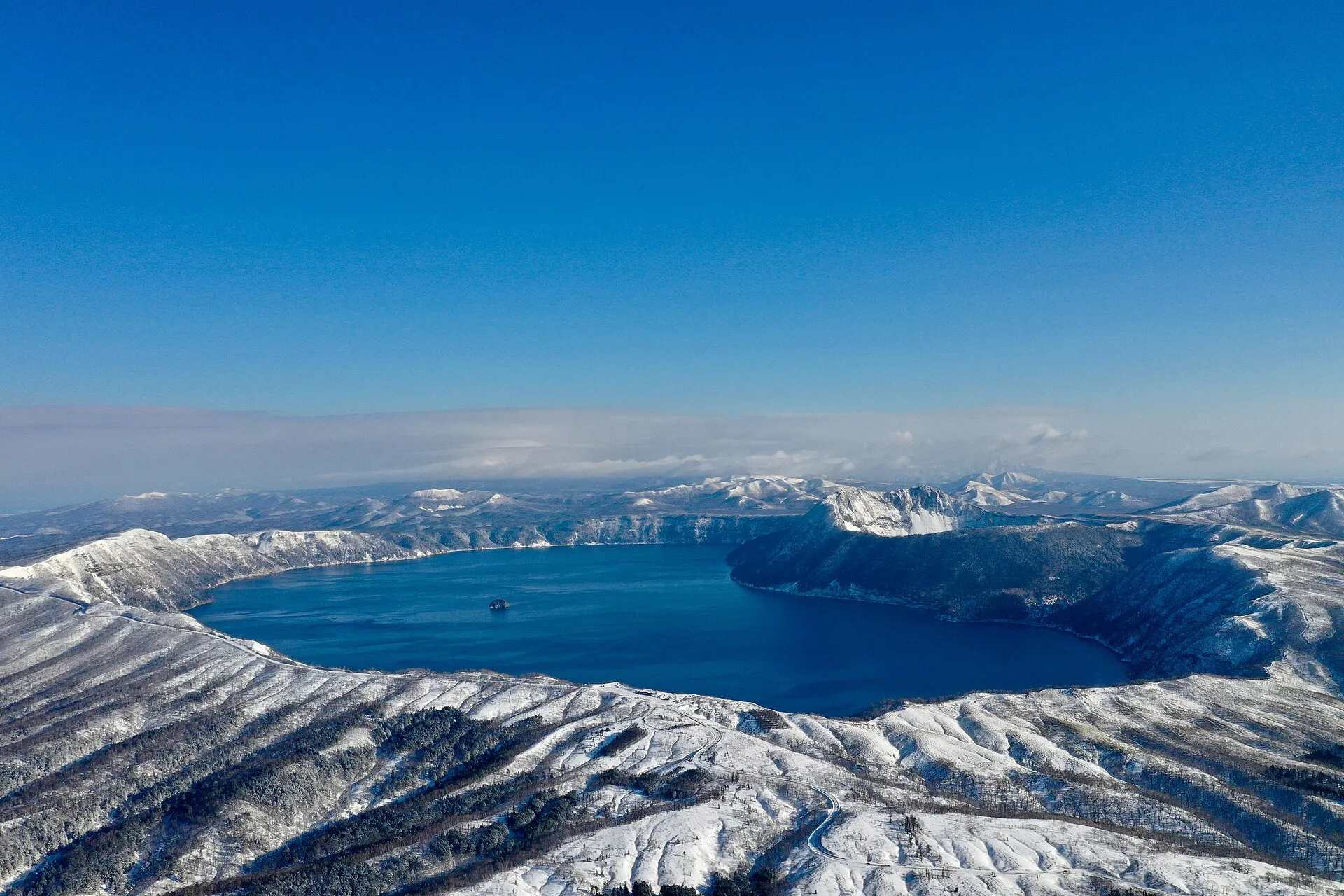 雪に覆われた外輪山に囲まれた冬の摩周湖